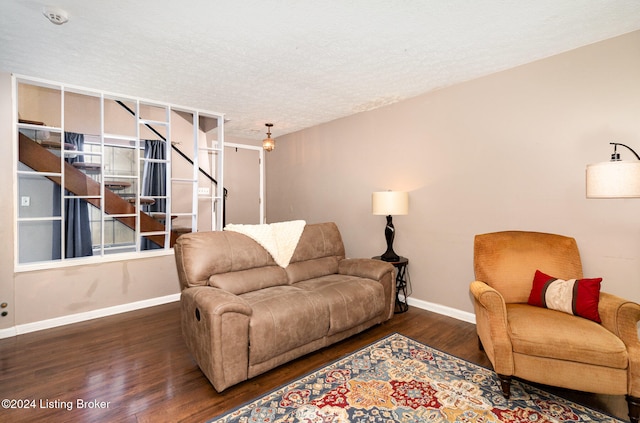 living room with a textured ceiling and dark hardwood / wood-style flooring