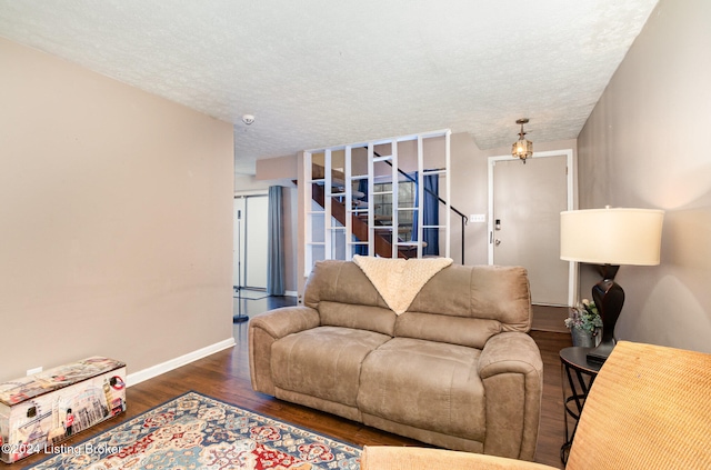 living room featuring a textured ceiling and dark hardwood / wood-style floors