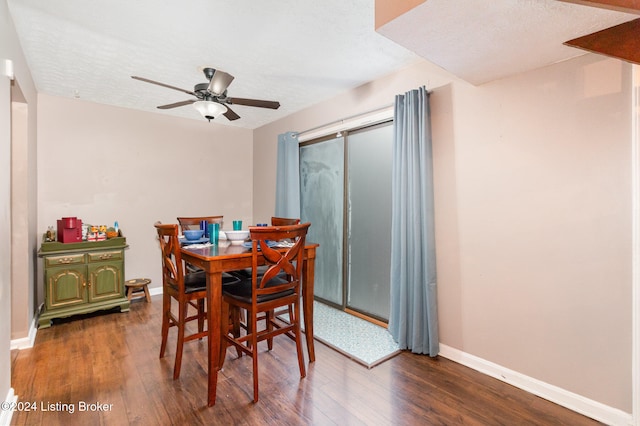 dining room featuring dark hardwood / wood-style floors, ceiling fan, and a textured ceiling