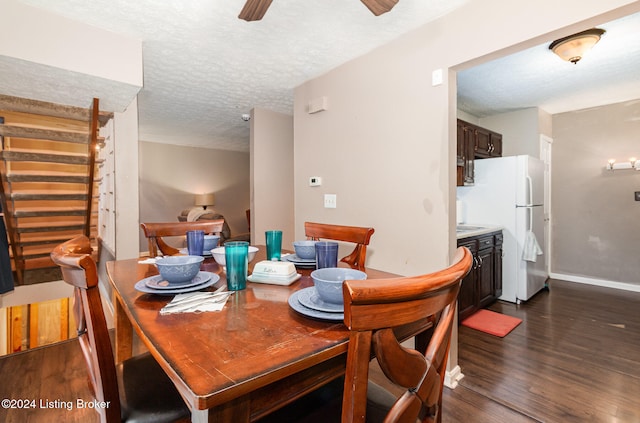 dining room featuring ceiling fan, dark wood-type flooring, and a textured ceiling