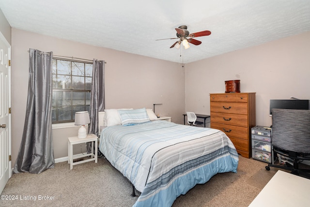 bedroom featuring ceiling fan, carpet floors, and a textured ceiling