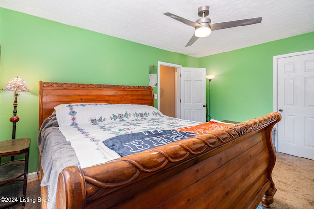 carpeted bedroom featuring a textured ceiling and ceiling fan