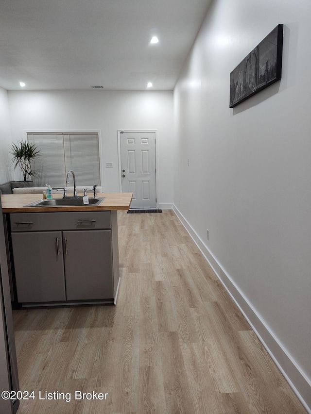 kitchen with wood counters, light hardwood / wood-style flooring, and sink