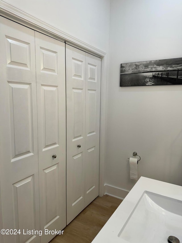 bathroom with baseboards, a closet, and wood finished floors