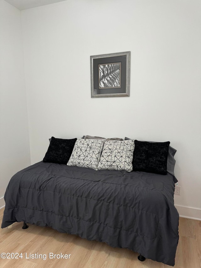 bedroom featuring baseboards and wood finished floors