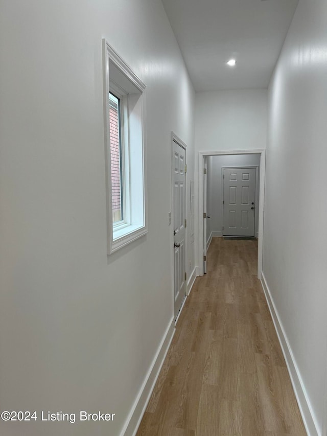 hallway with wood finished floors and baseboards