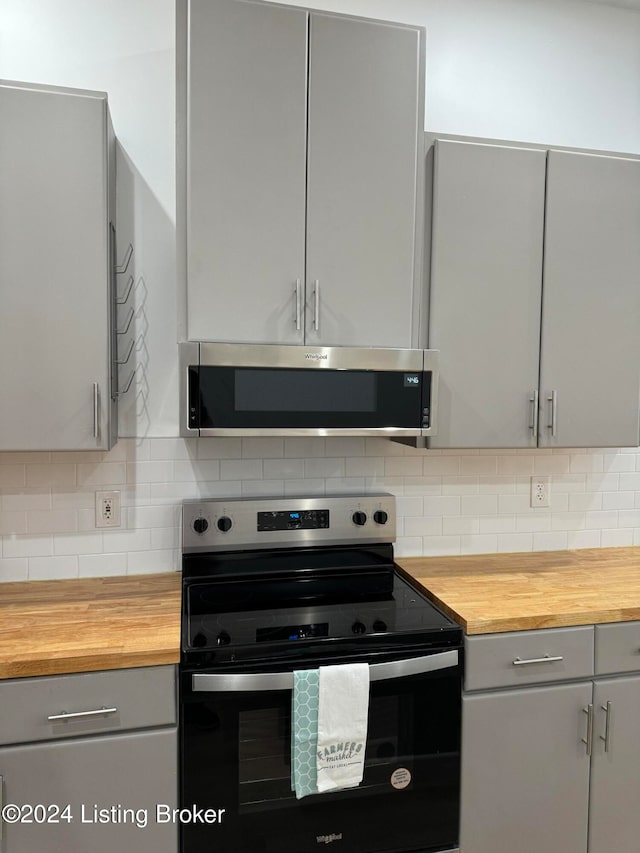 kitchen featuring gray cabinets, black range with electric cooktop, stainless steel microwave, and wood counters