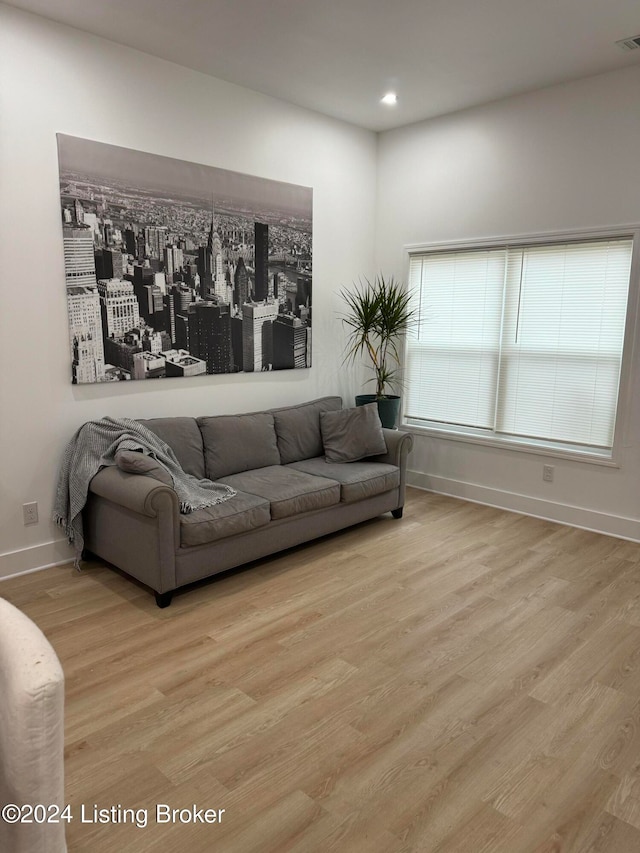 living area featuring visible vents, baseboards, wood finished floors, and recessed lighting