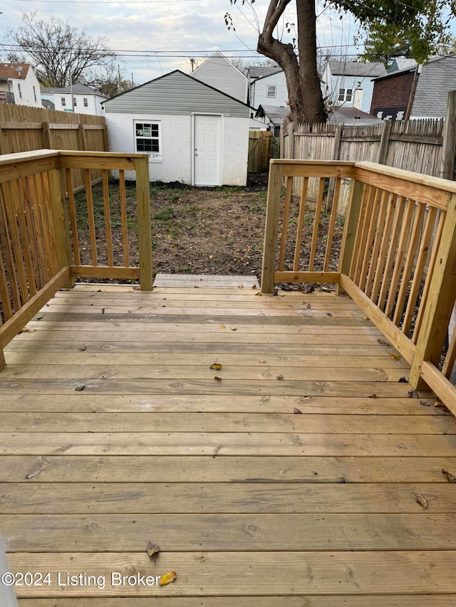 wooden deck with an outbuilding and a fenced backyard