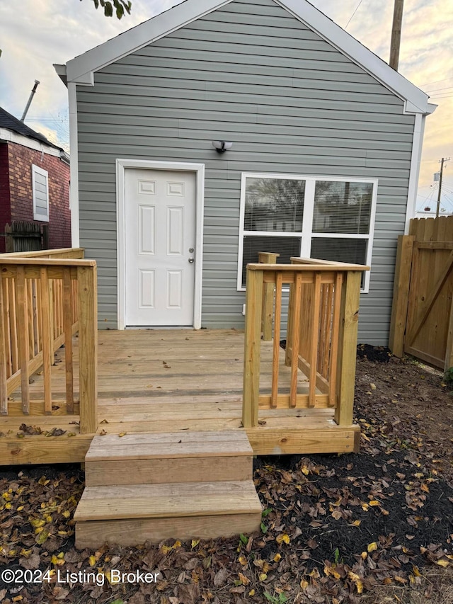 back house at dusk featuring a deck