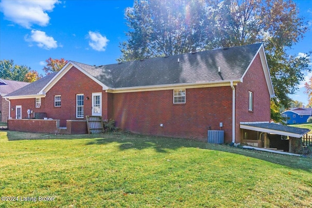 rear view of house with a lawn and central AC