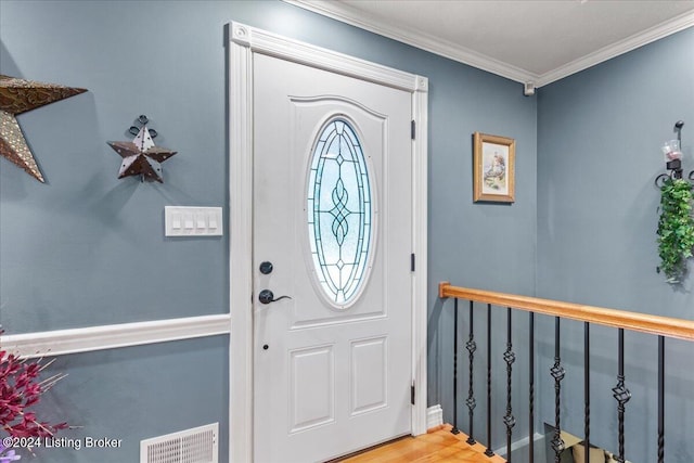 entryway with hardwood / wood-style flooring and crown molding