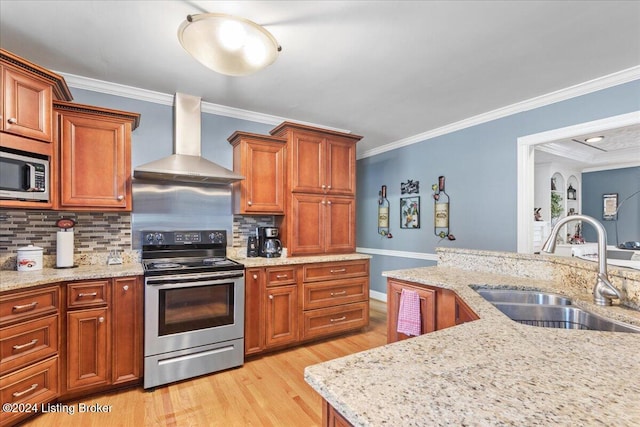 kitchen with wall chimney exhaust hood, stainless steel appliances, crown molding, sink, and light hardwood / wood-style flooring