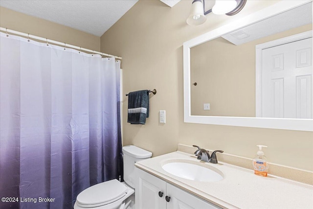 bathroom with a textured ceiling, vanity, and toilet