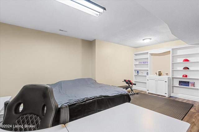 bedroom featuring hardwood / wood-style flooring and a textured ceiling