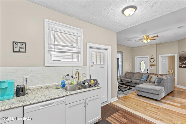 kitchen featuring dishwasher, decorative backsplash, light hardwood / wood-style floors, and plenty of natural light