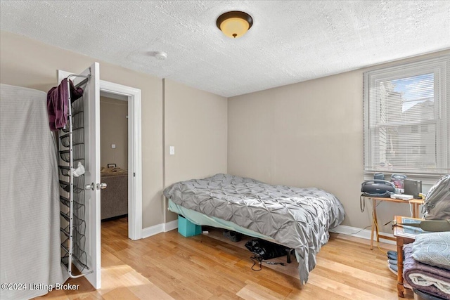 bedroom with hardwood / wood-style floors and a textured ceiling