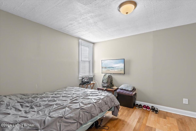 bedroom featuring a textured ceiling and hardwood / wood-style flooring