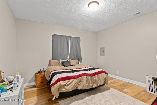 bedroom featuring wood-type flooring and a textured ceiling