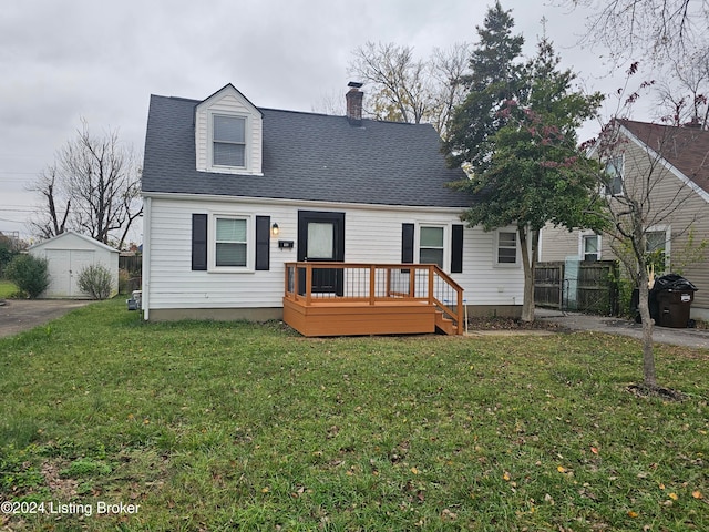 new england style home featuring a front yard, a shed, and a wooden deck