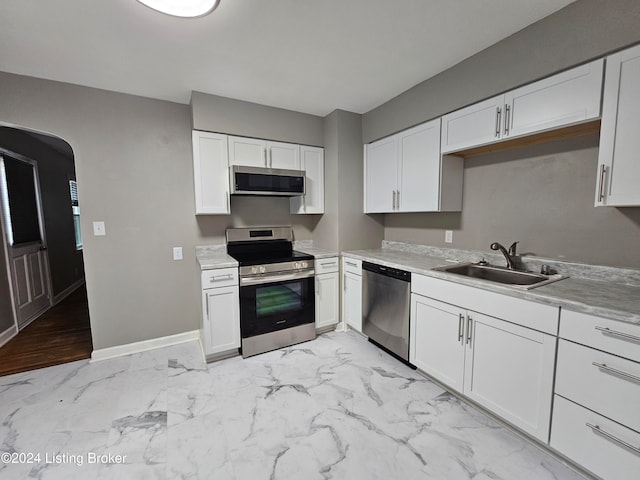 kitchen featuring white cabinets, light hardwood / wood-style floors, sink, and appliances with stainless steel finishes