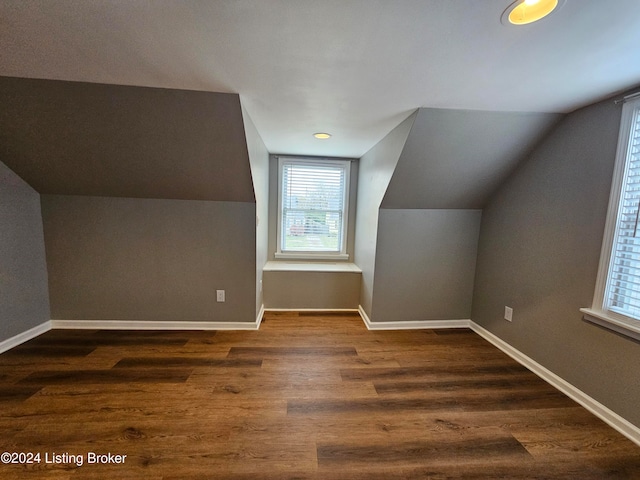 additional living space featuring lofted ceiling and dark wood-type flooring