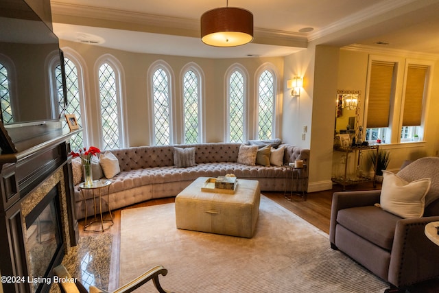 living room with a fireplace, ornamental molding, and light wood-type flooring