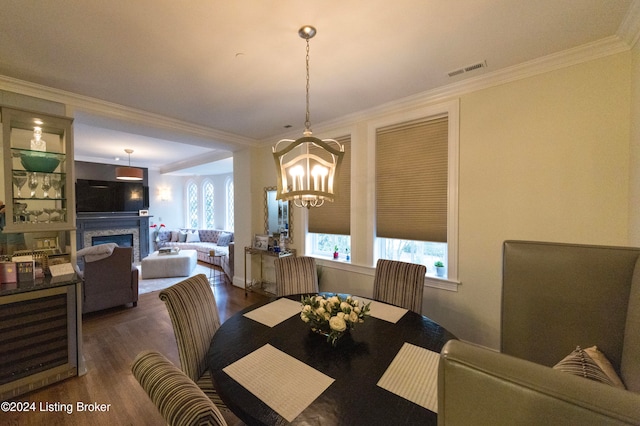 dining space with dark hardwood / wood-style floors, crown molding, and a chandelier