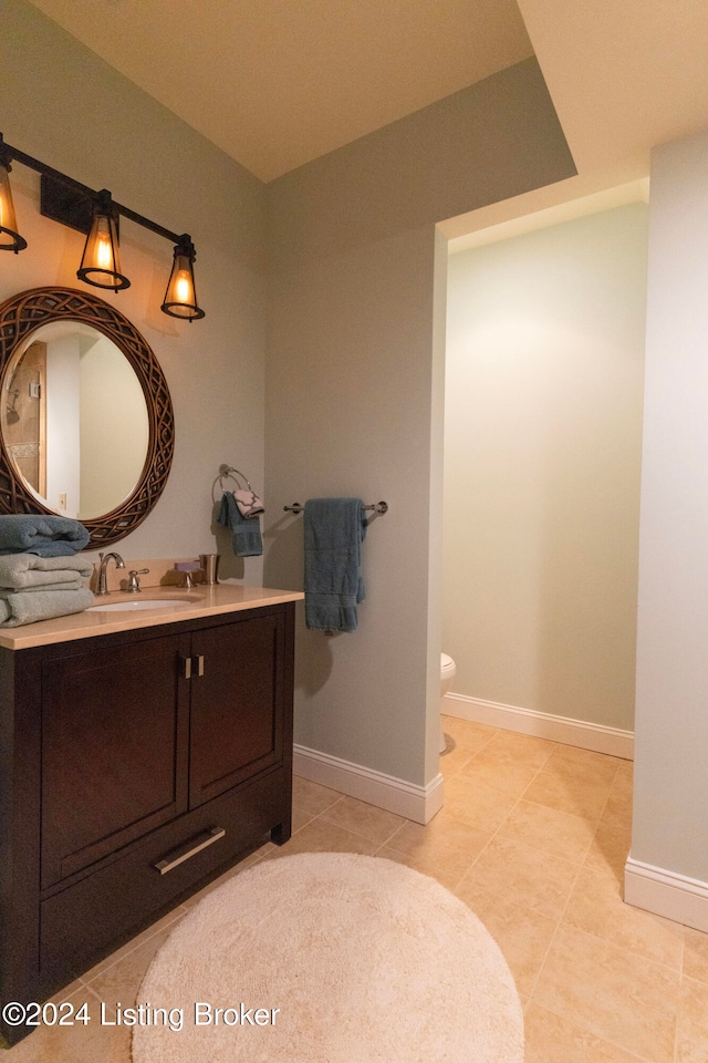 bathroom featuring tile patterned flooring, vanity, and toilet