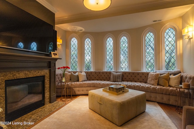 living room featuring plenty of natural light, light wood-type flooring, and a high end fireplace