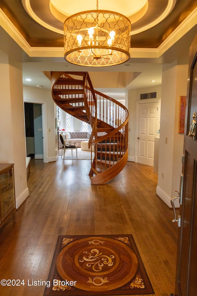 foyer entrance featuring hardwood / wood-style flooring, crown molding, and a tray ceiling