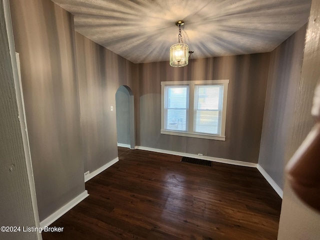 empty room featuring dark hardwood / wood-style floors and a chandelier