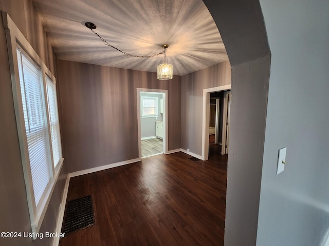 spare room featuring dark hardwood / wood-style floors and a notable chandelier