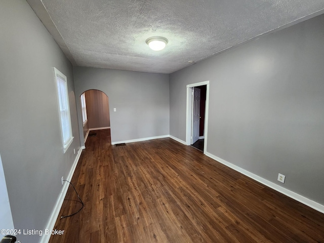 spare room with dark hardwood / wood-style flooring and a textured ceiling