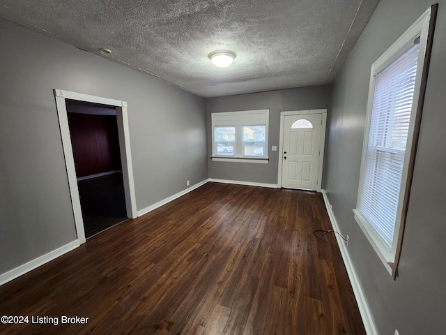 foyer featuring a textured ceiling and dark hardwood / wood-style flooring