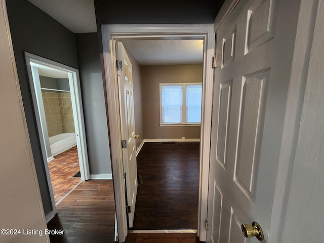 corridor with hardwood / wood-style flooring