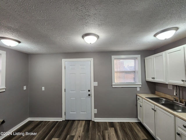 kitchen with white cabinets, sink, and dark wood-type flooring