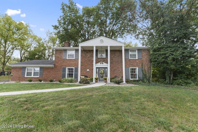 neoclassical home featuring a front yard