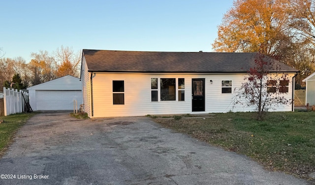 view of front facade with an outbuilding, a garage, and a front yard