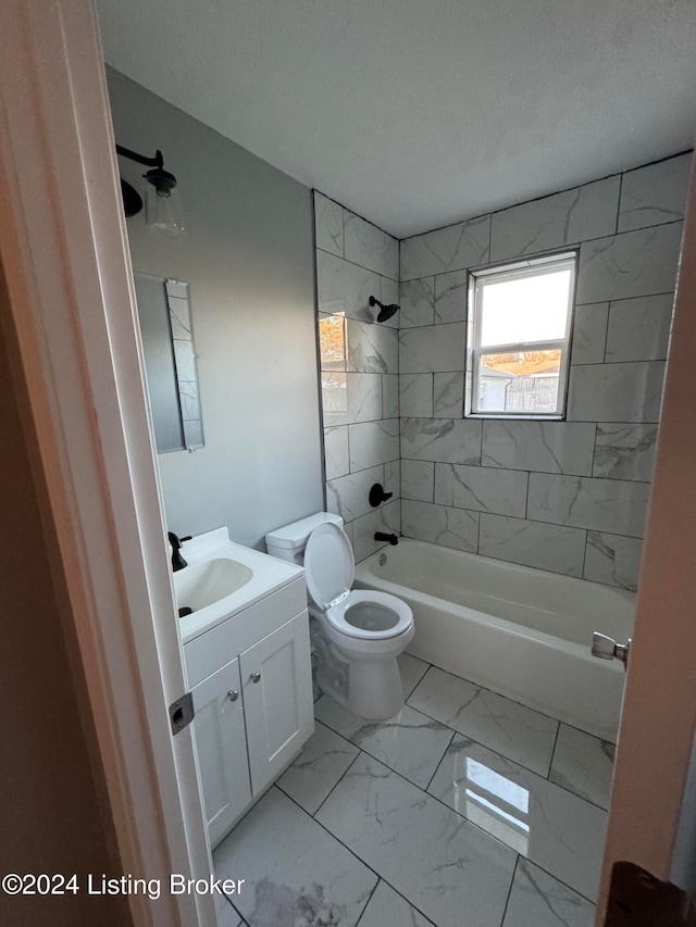 full bathroom featuring vanity, tiled shower / bath combo, and toilet