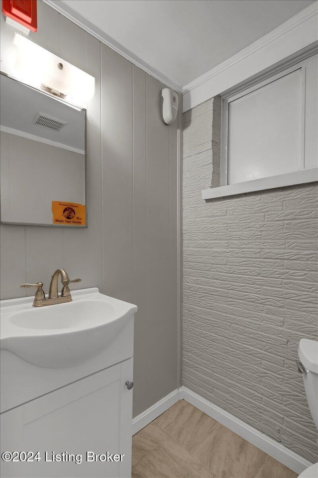 bathroom with vanity, toilet, and ornamental molding