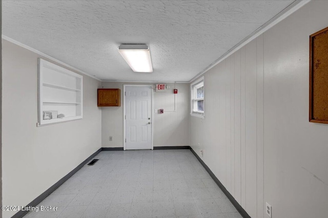 unfurnished room with crown molding and a textured ceiling