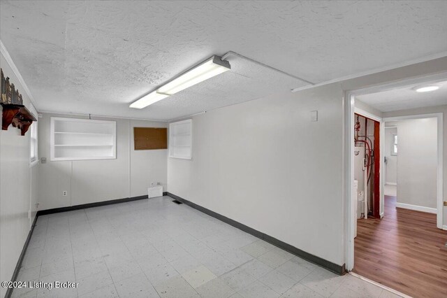 empty room featuring a textured ceiling and electric water heater