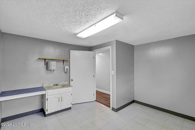 bathroom featuring a textured ceiling and sink