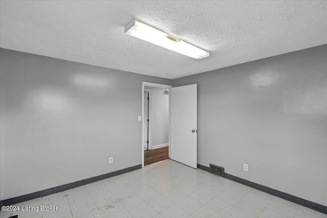 unfurnished room featuring a textured ceiling