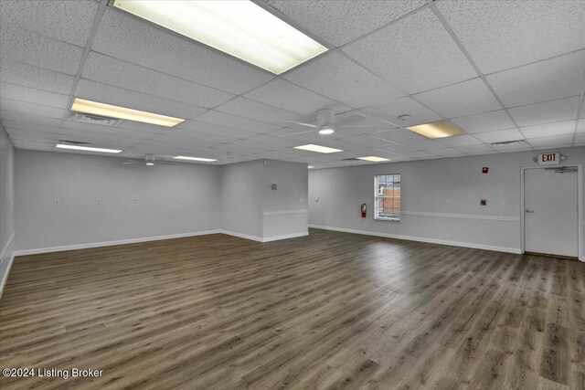 unfurnished room with a paneled ceiling and dark hardwood / wood-style flooring