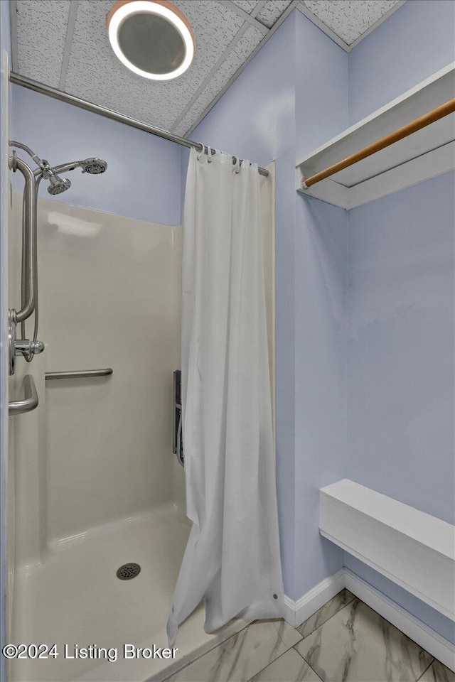 bathroom with a shower with curtain and a drop ceiling