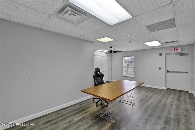 unfurnished office featuring wood-type flooring, a paneled ceiling, and ceiling fan