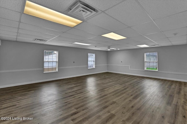 empty room with a drop ceiling and dark hardwood / wood-style flooring