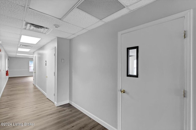 hallway featuring a paneled ceiling and wood-type flooring